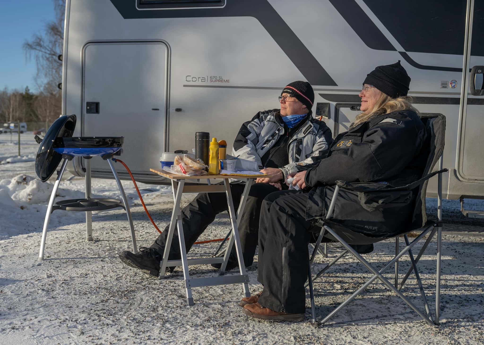 Par njuter av vintercamping vid First Camp Lugnet Falun, omgivna av snö och natur