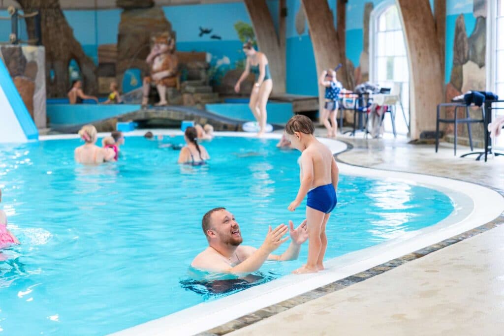 Familj som badar tillsammans i inomhusbadlandet på First Camp Hasmark Strand