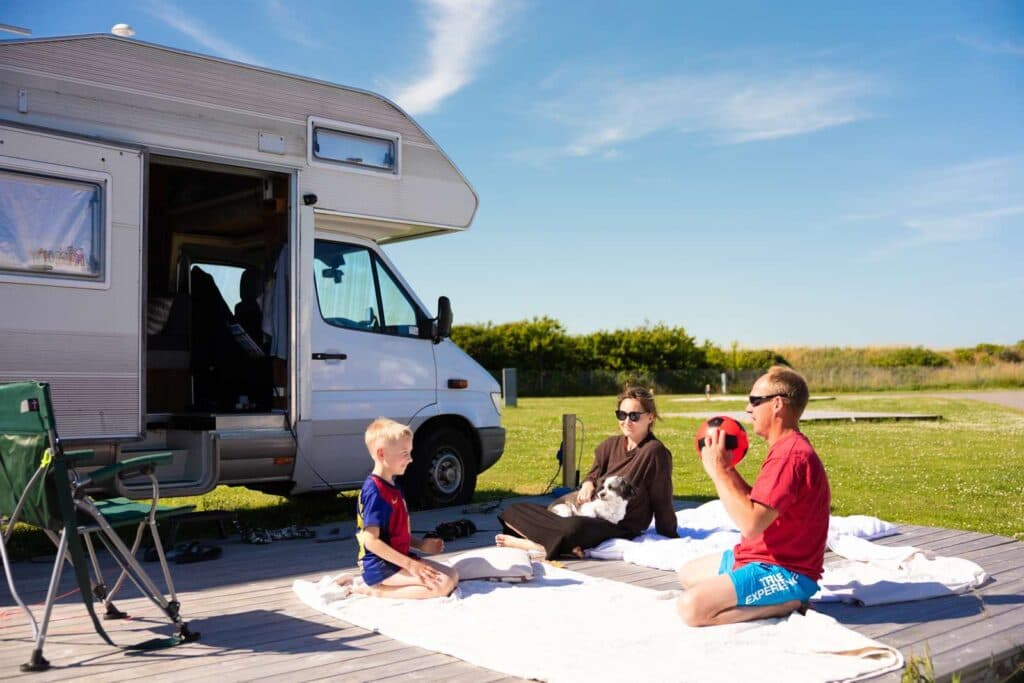 Familie hygger sig uden for campingvognen på Lakolk Strand – Rømø camping