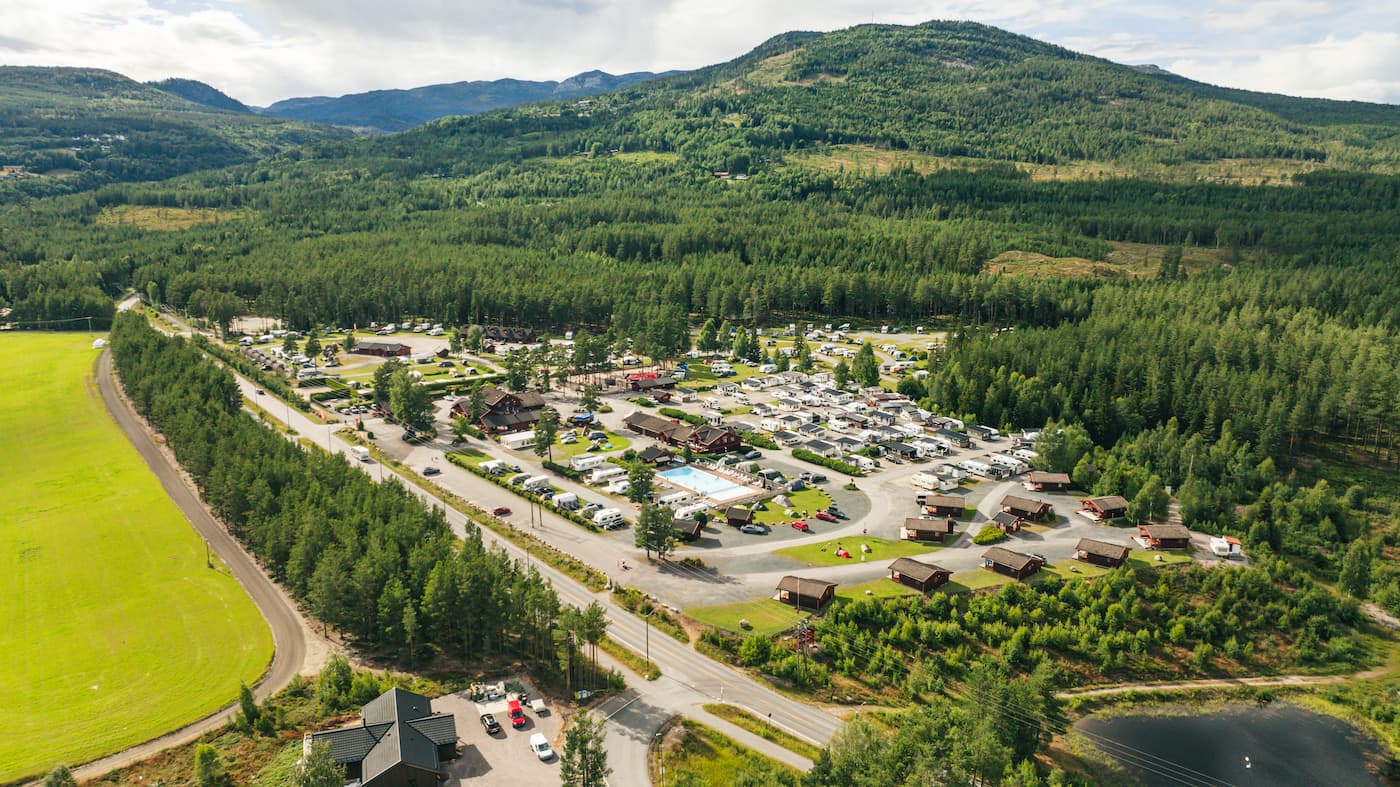 Familievenlig camping i Norge – Glade campister nyder ferien i en norsk campinghytte omgivet af smuk natur.