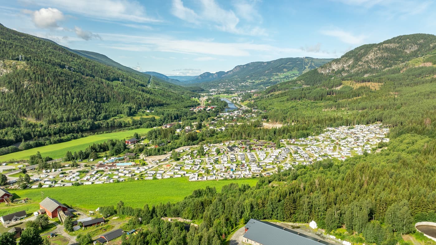 Naturskøn camping i Norge – Udsigt over en idyllisk campingplads i Norge med bjerge og sø i baggrunden.