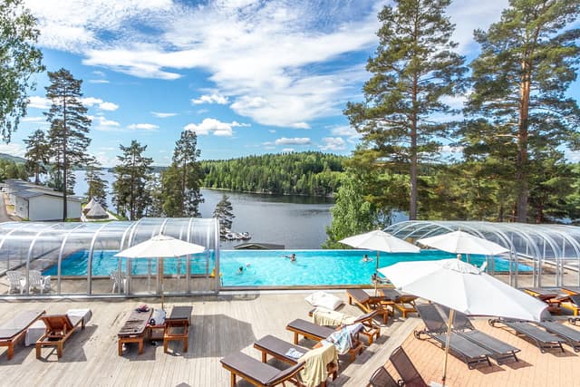 Utsikt över poolområdet på camping med solstolar och badglada barn