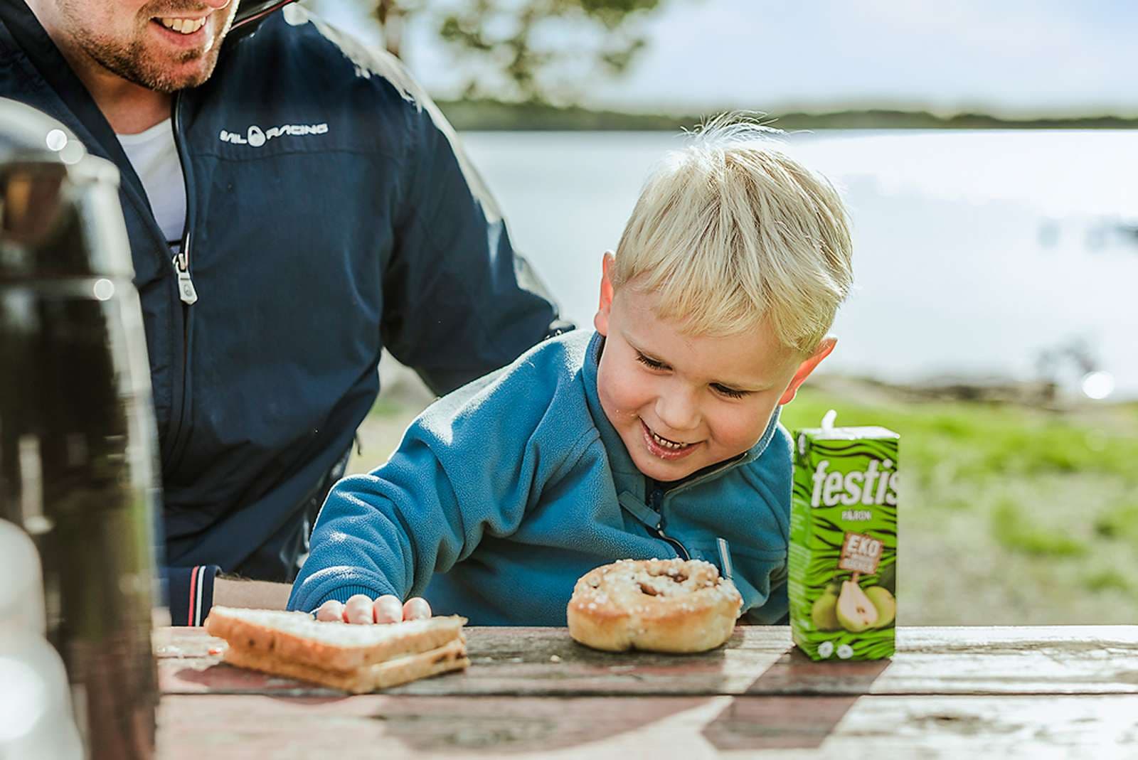 Barn som fikar utomhus med festis och bulle
